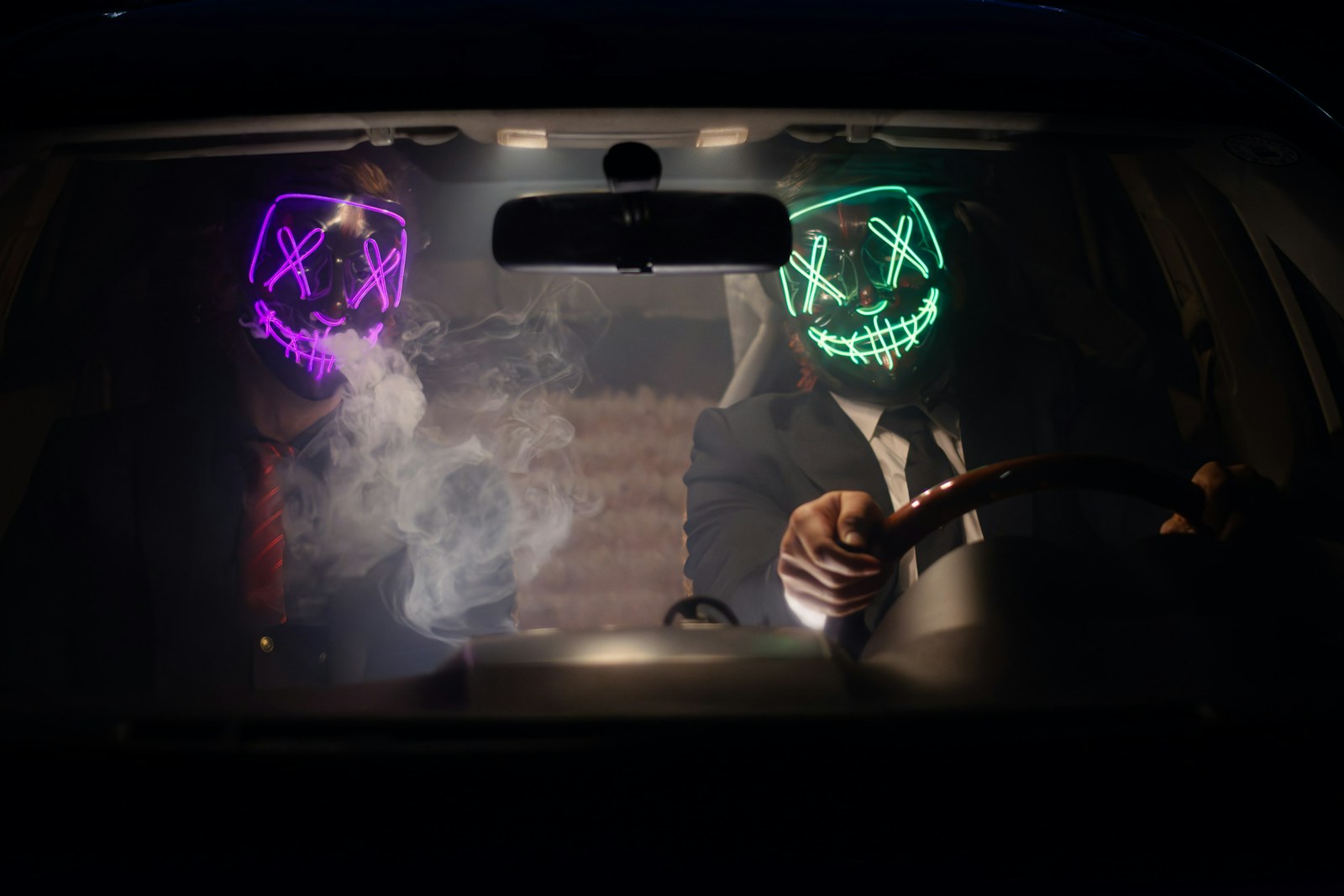 Neon mask guys chilling inside car
