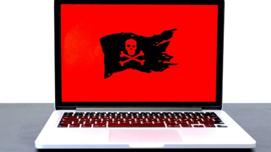 Laptop displaying a pirate flag / jolly roger on a red screen, possibly indicating malware, hackers or a different computer problem. If you like that image, consider donating at https://sharethemeal.org/donate - thanks!